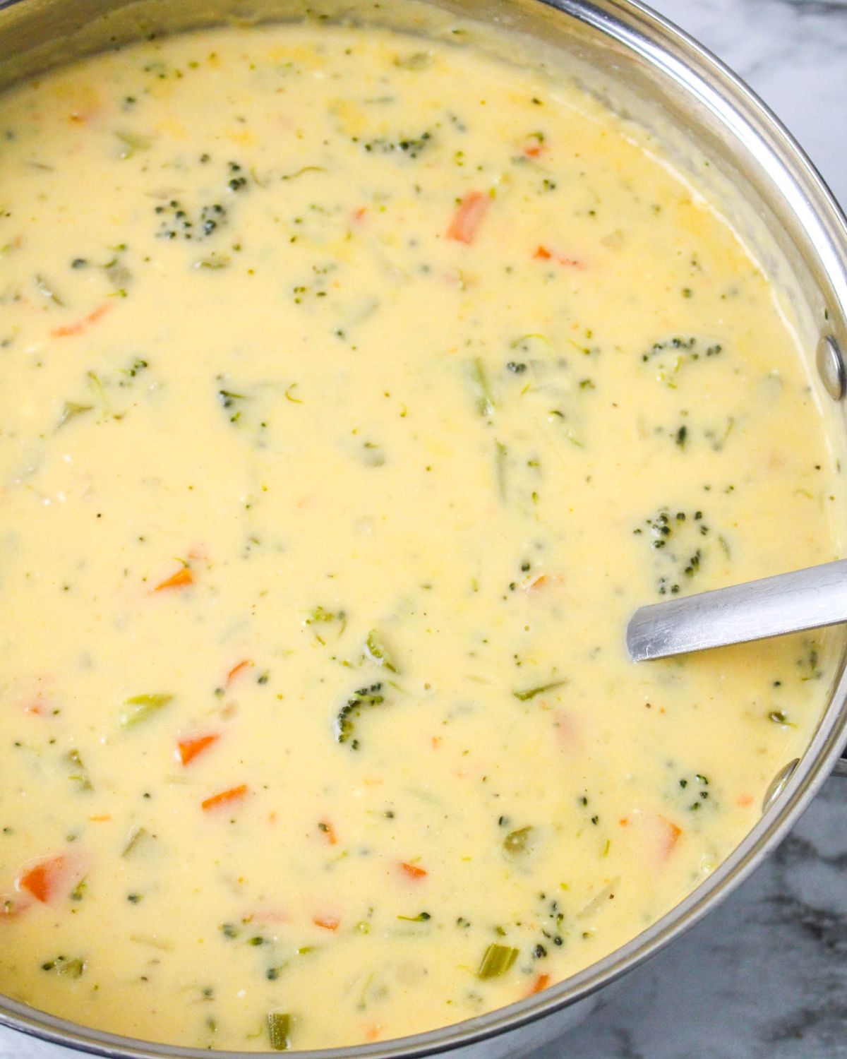 A soup pot with creamy broccoli cheddar beer soup.