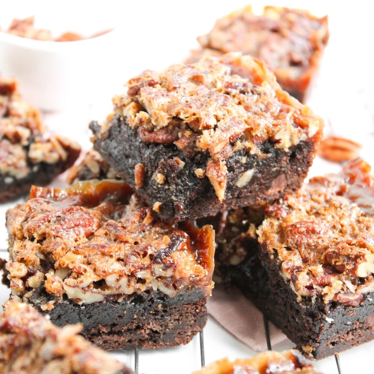 Pecan pie brownies stacked on a white plate.