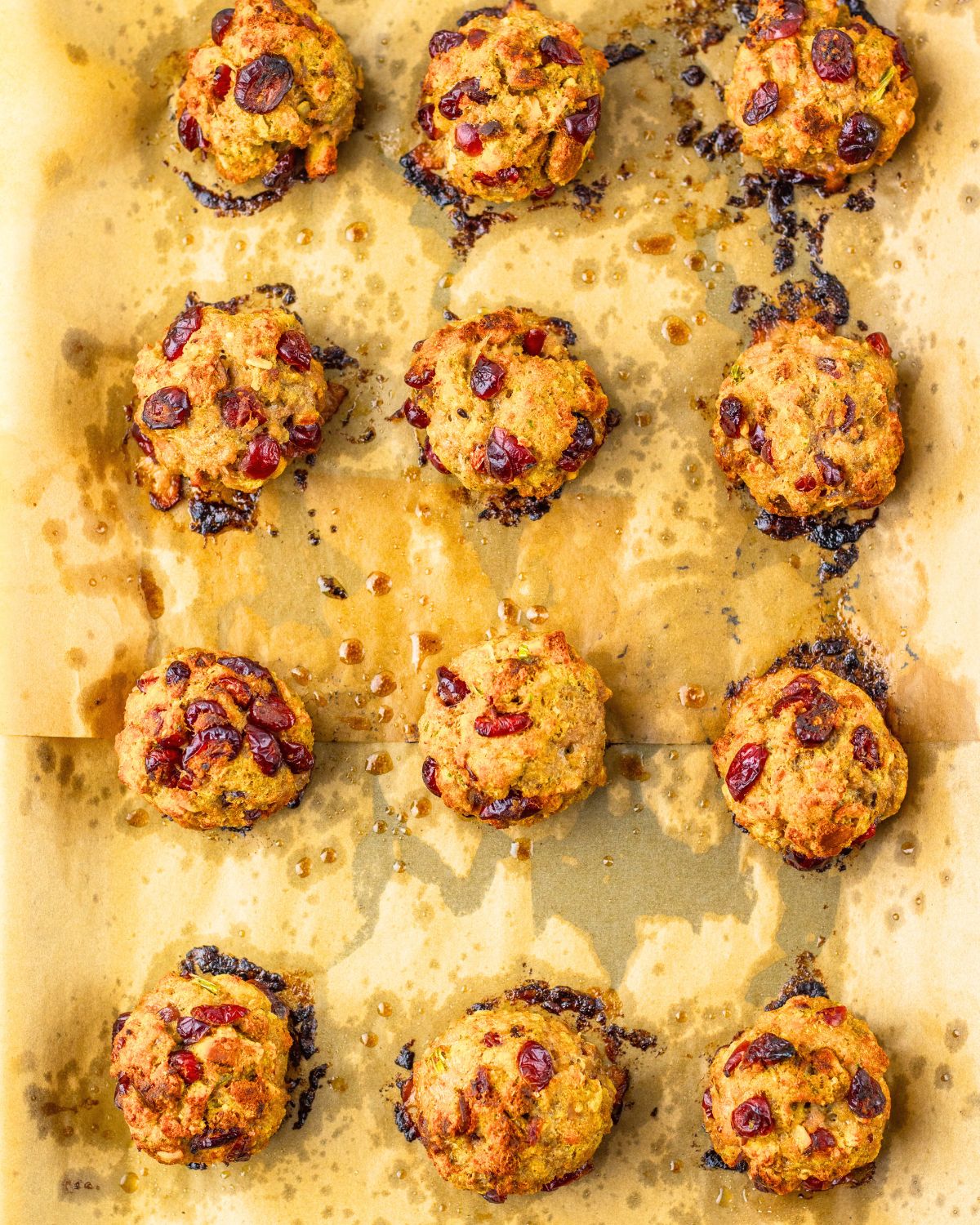 Baked ground turkey and dried cranberry balls to make a turkey cranberry ball on a baking sheet.