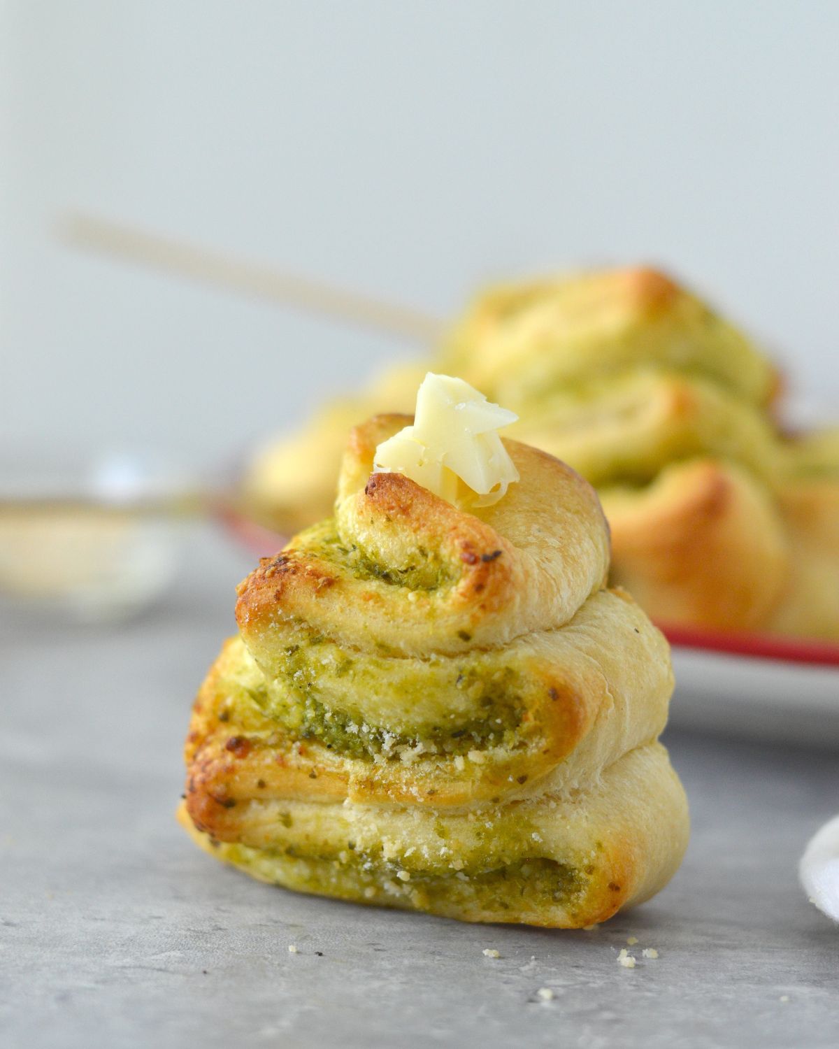 Baked crescent dough filled with basil pesto and shaped into a Christmas Tree and topped with a star shape mozzarella cheese.