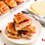 A plate of turkey sliders with Gouda cheese and cranberry.