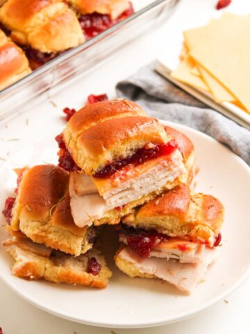 A plate of turkey sliders with Gouda cheese and cranberry.