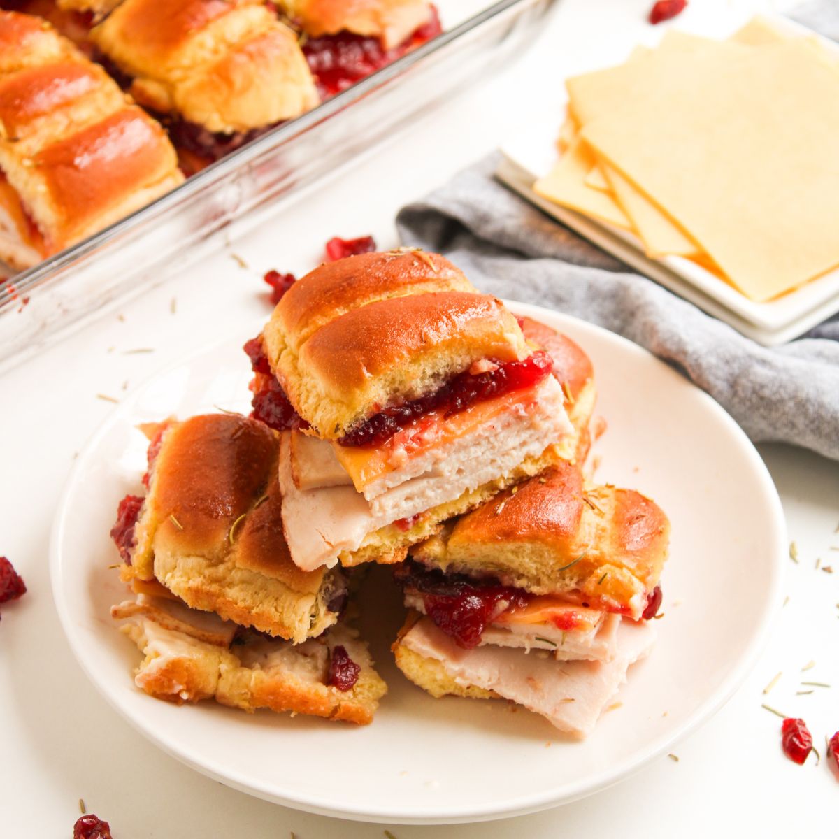 A plate of turkey sliders with Gouda cheese and cranberry.