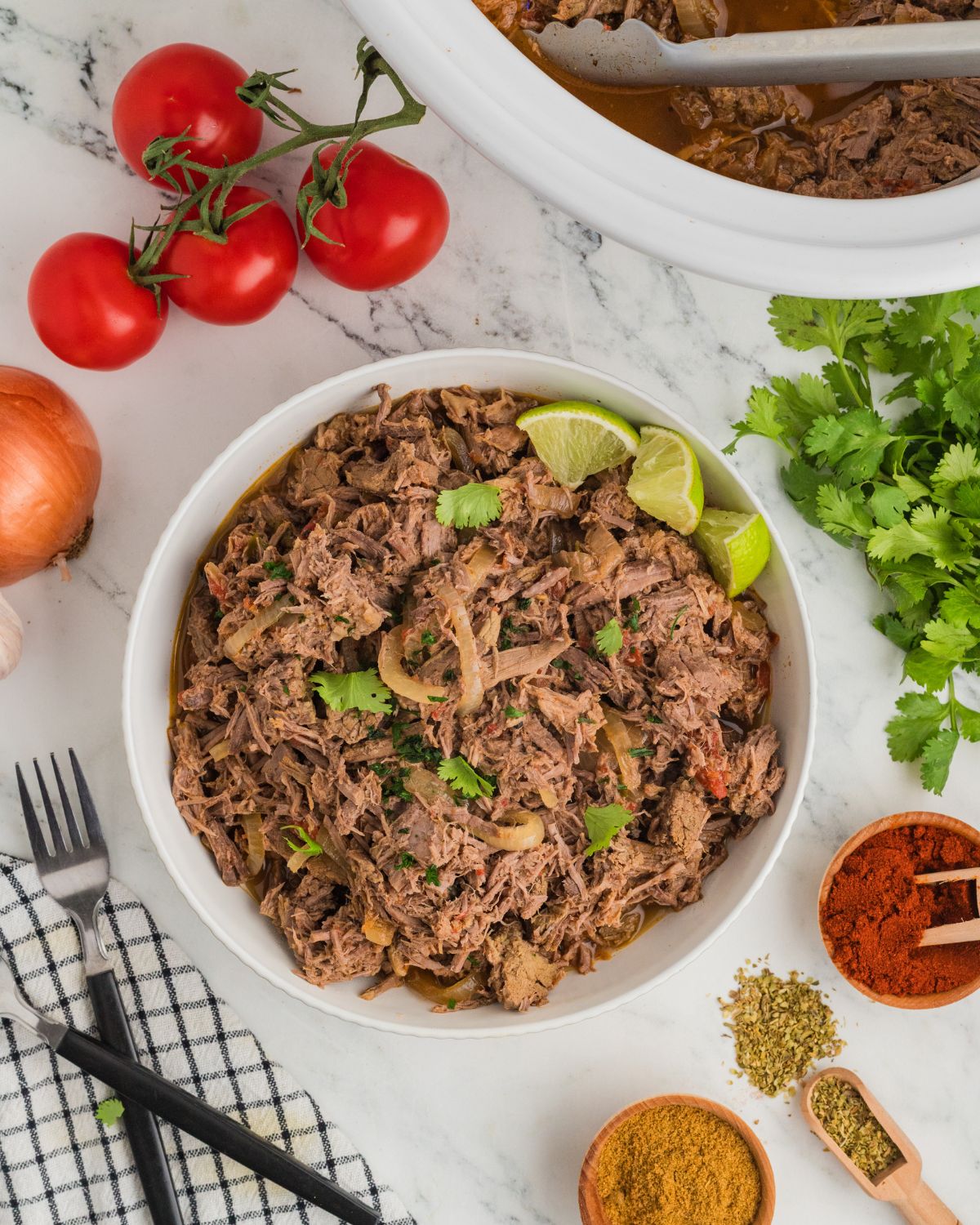 Shredded Mexican Beef with lime wedges made in the slow cooker.