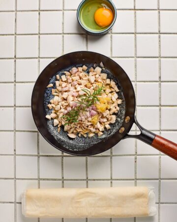 A saute pan with shallots, mushrooms sauteeing to make Mini Beef Wellington Bites.
