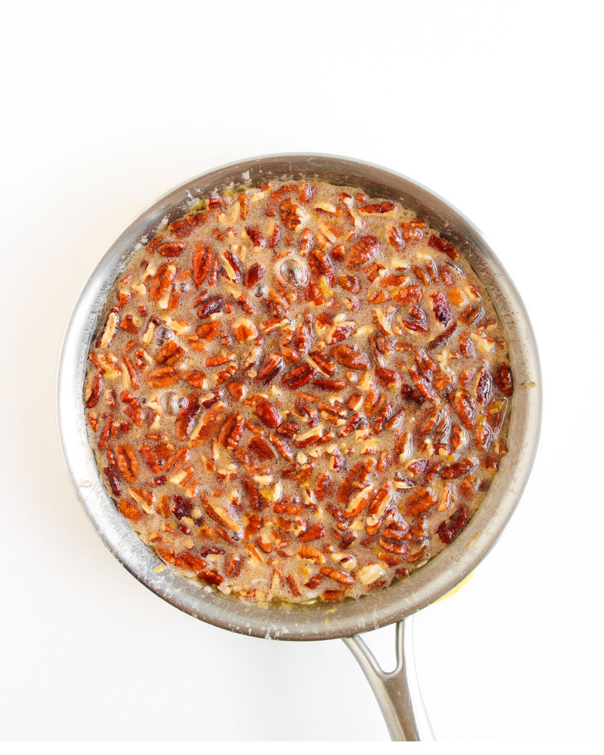 A sauce pan with the toppings for a pecan pie dip.