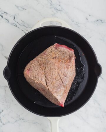 A seasoned rump roast being browned to make shredded beef for Mexican shredded beef.