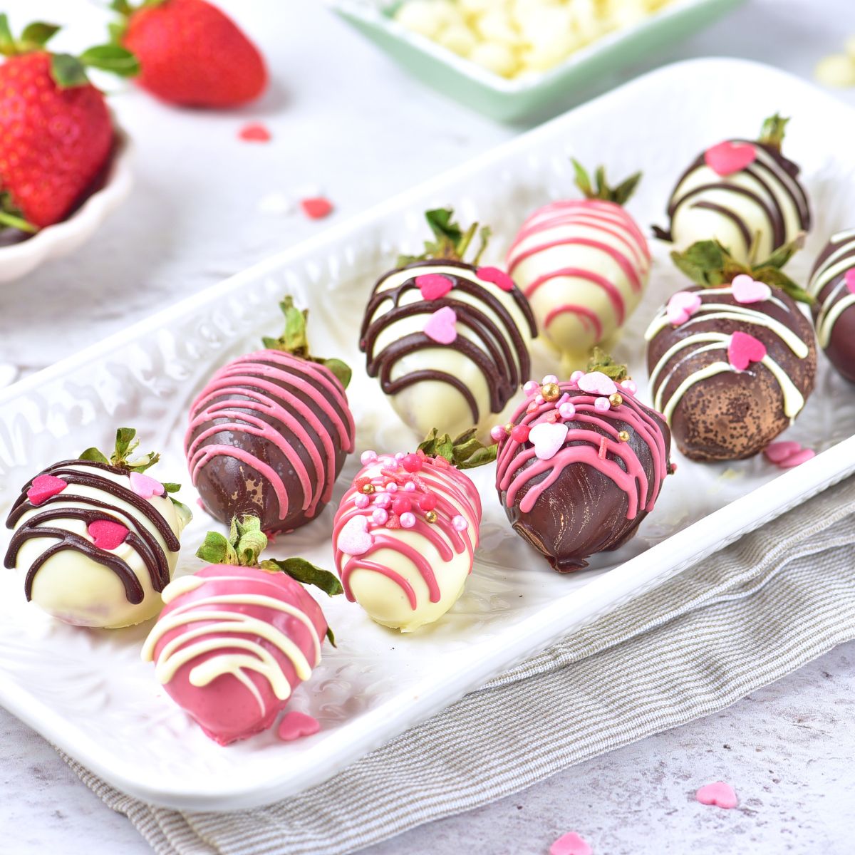 Strawberries covered in melted chocolate with a drizzle of melted colored chocolate for holiday celebration.