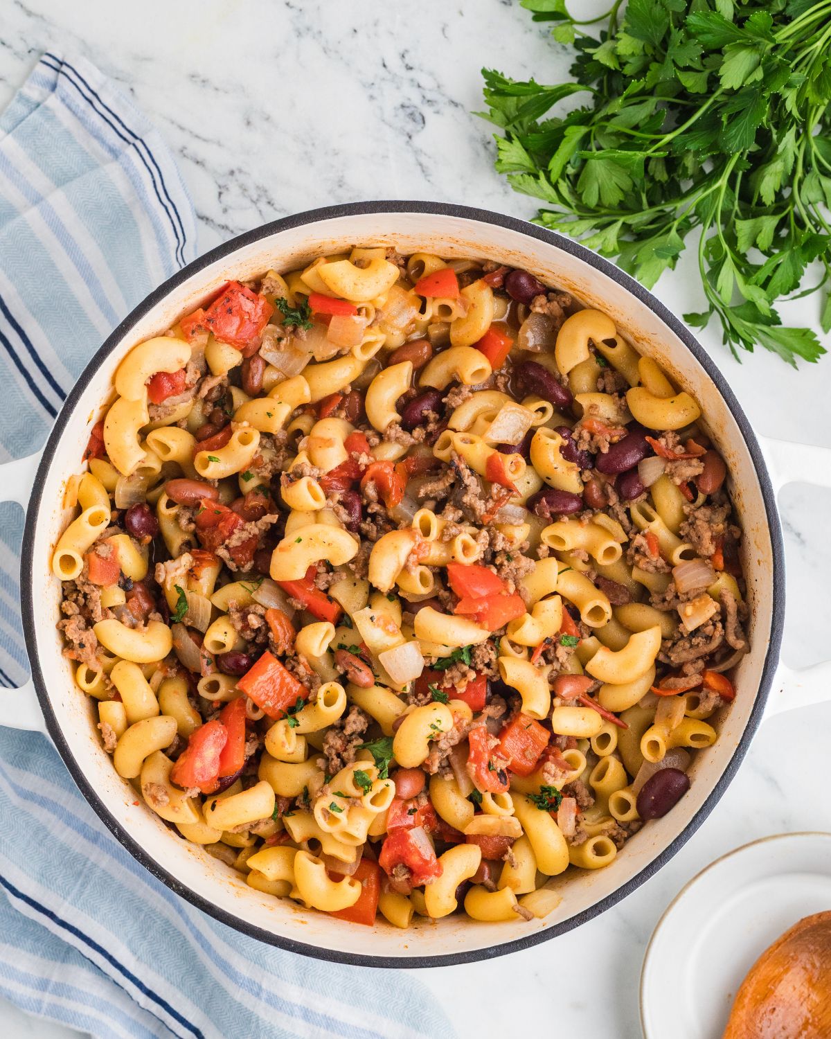 One pot chili mac and cheese in a dutch oven with ground beef and chili beans.