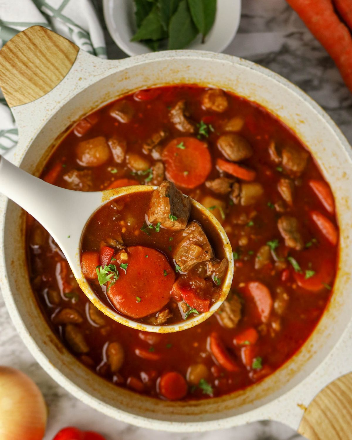 A dutch oven with beef, carrots and potatoes for a Hungarian Goulash beef stew.