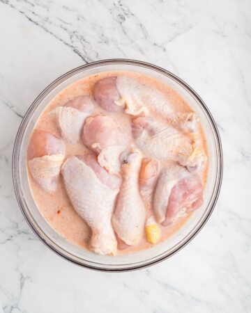 Chicken drumstick buttermilk marinade in a large bowl to make oven fried drumsticks.