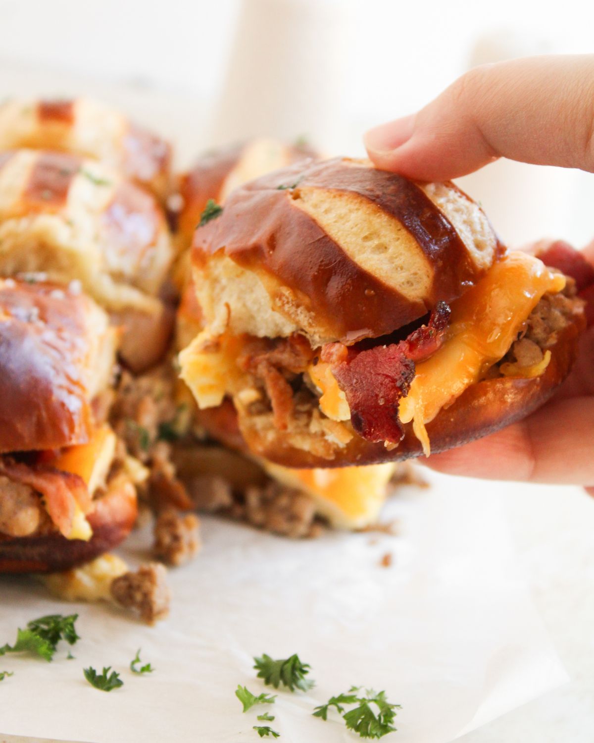 Breakfast sliders with bacon eggs and cheese and one slider be