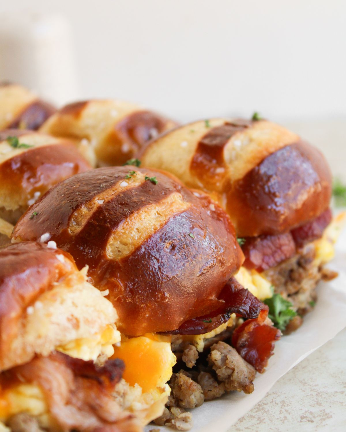 Egg Breakfast Sliders on Pretzel Buns on a white plate.