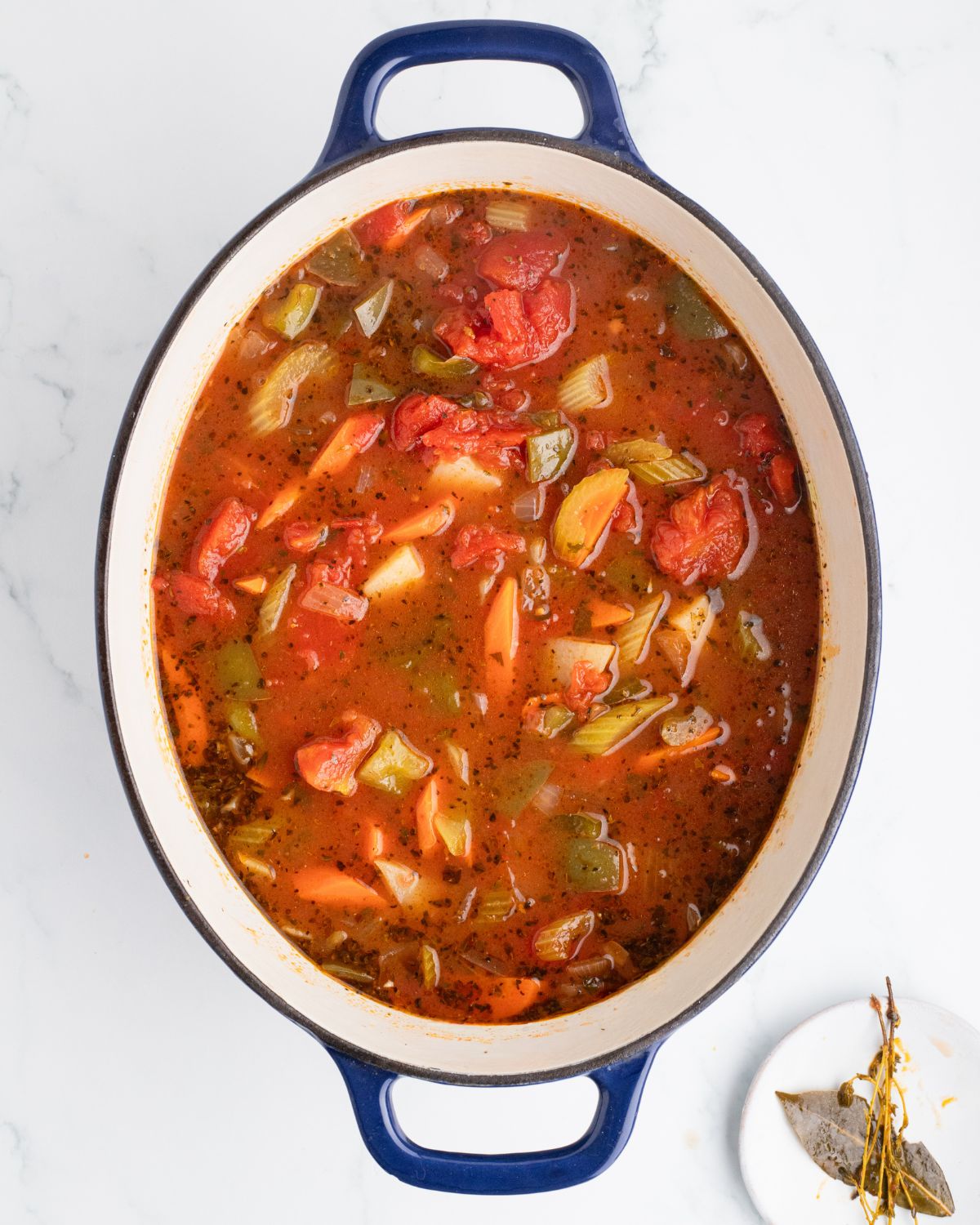 A dutch oven with manhattan clam chowder in the pot.