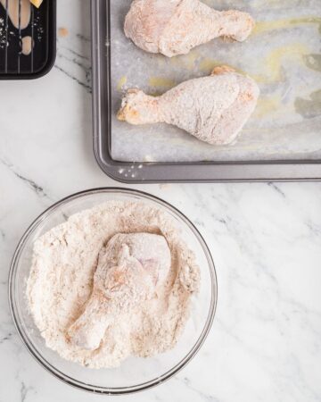 Drumsticks dredged in seasoned flour to make oven baked oven fried chicken drumsticks.
