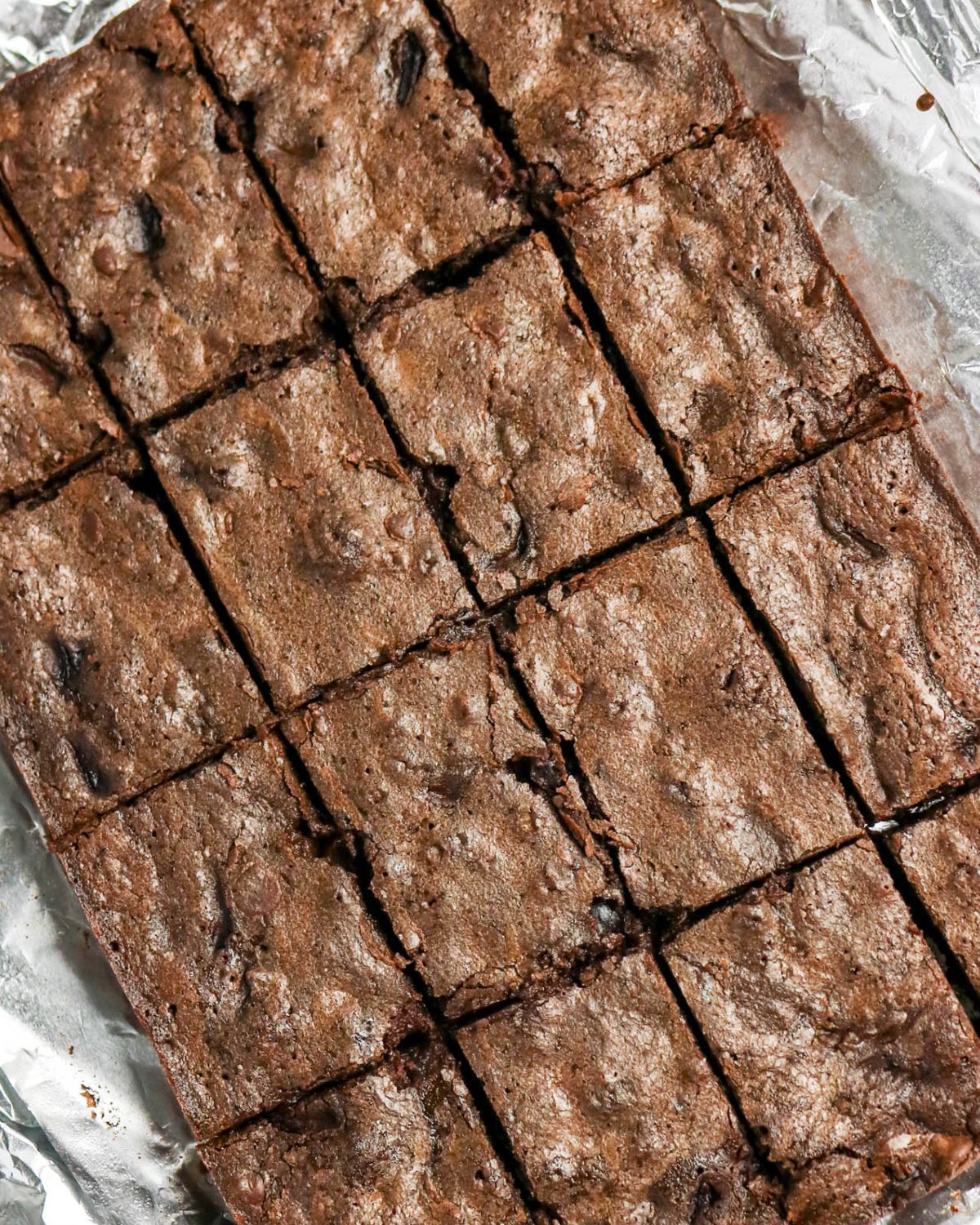 Homemade cherry brownies with fresh cherries that are sliced on an parchment paper.