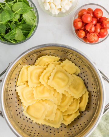Fresh ravioli cooked and resting in a strainer to make Caprese Ravioli. 
