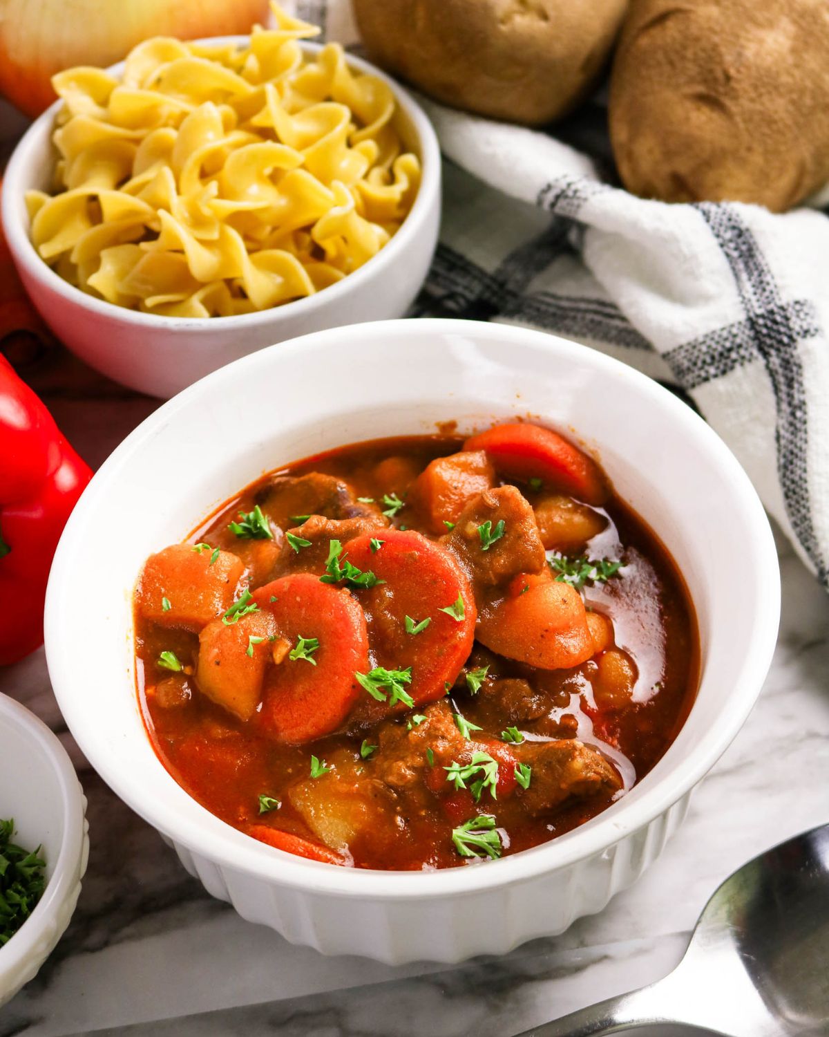 A bowl of Hungarian Goulash with egg noodles on the side. 