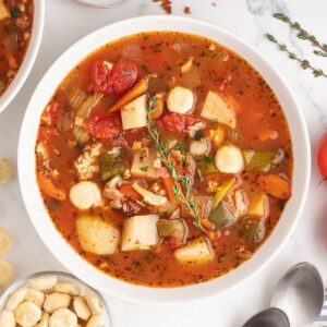 Manhattan Clam Chowder in a bowl topped with a sprig of fresh thyme.