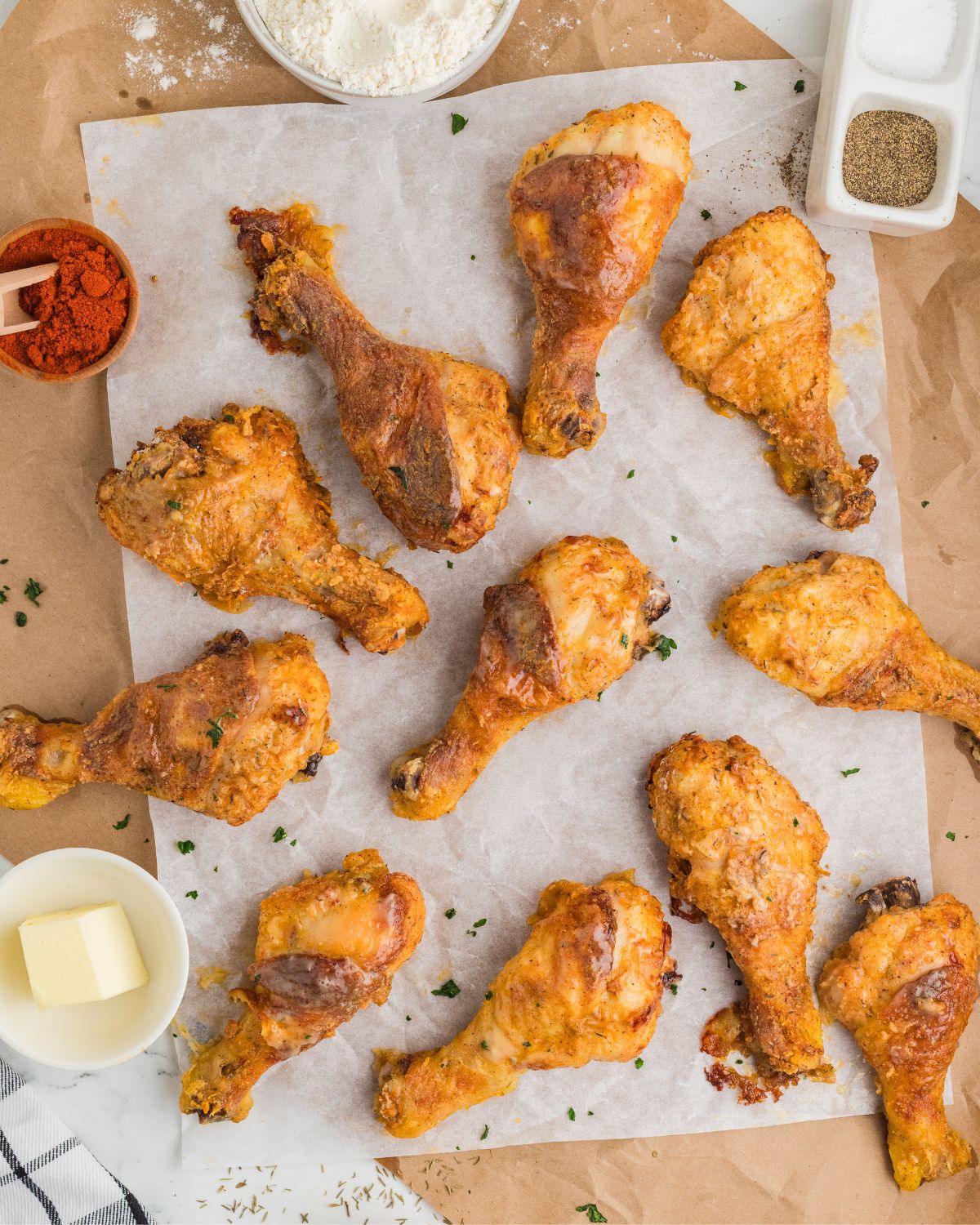 Crispy baked fried chicken on a wooden plate on parchment paper.