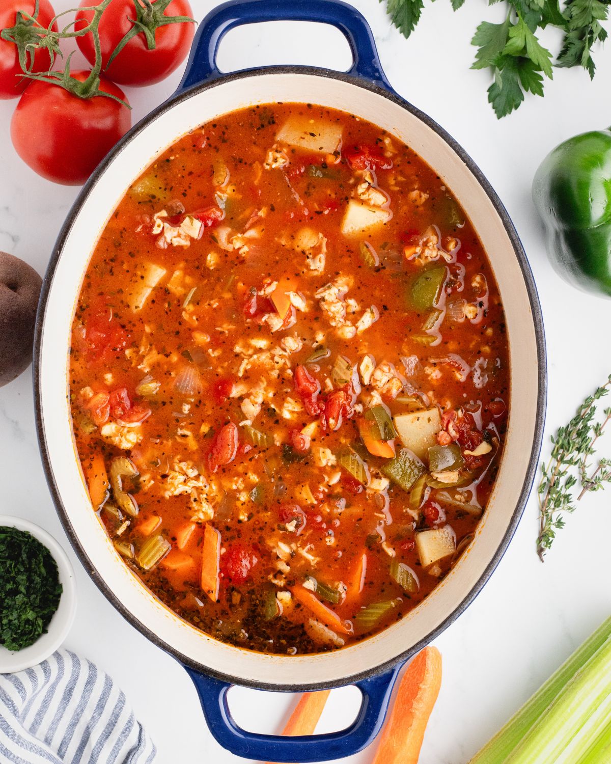 A dutch oven with a recipe for Manhattan Clam Chowder in the pot.