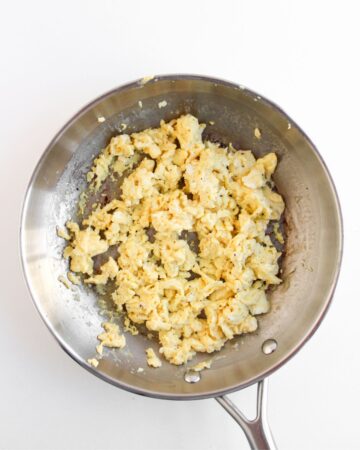 Scrambled eggs in a saute pan to make eggs for breakfast sliders.