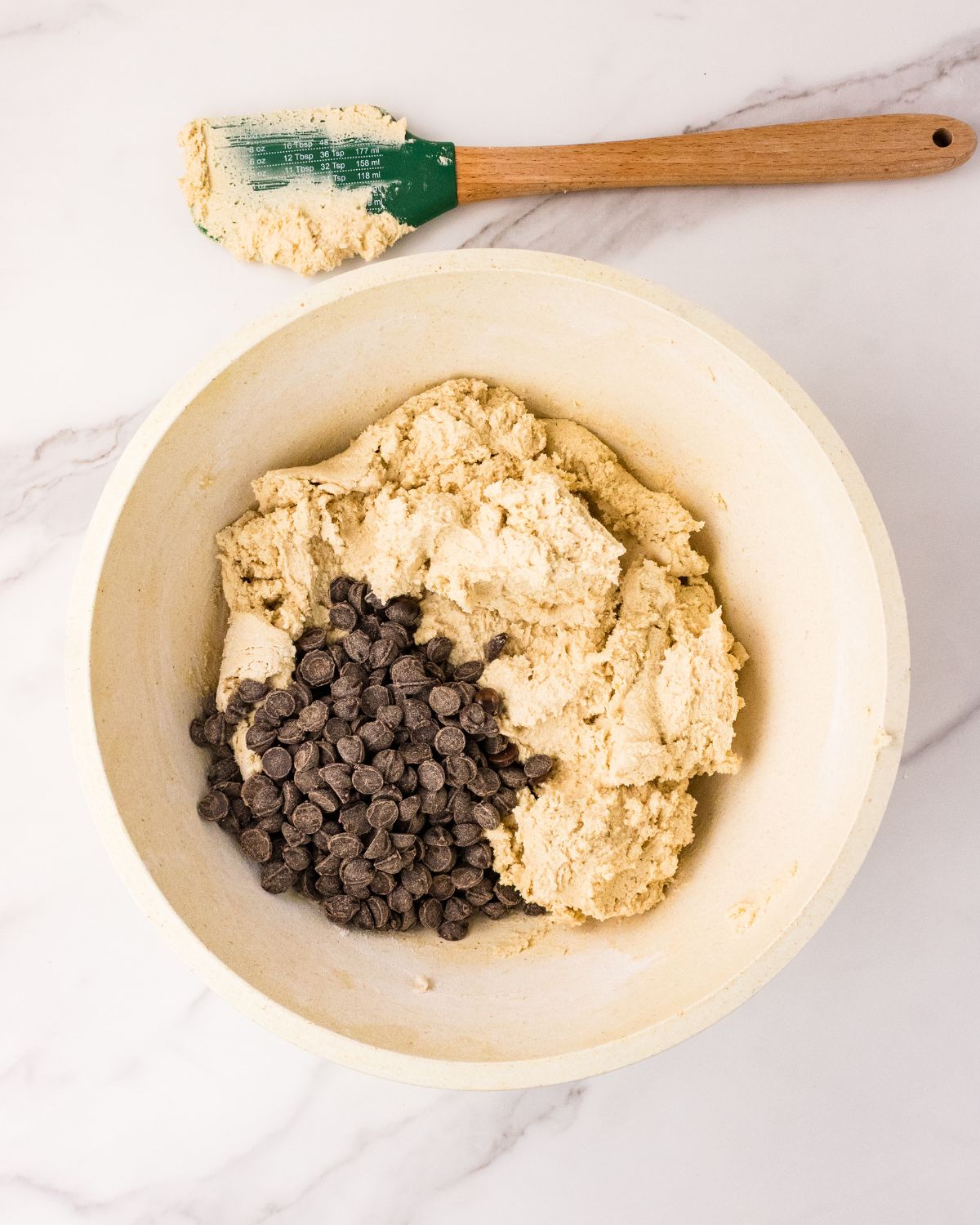 Adding chocolate chips to cookie dough to make eggless chocolate chip cookies