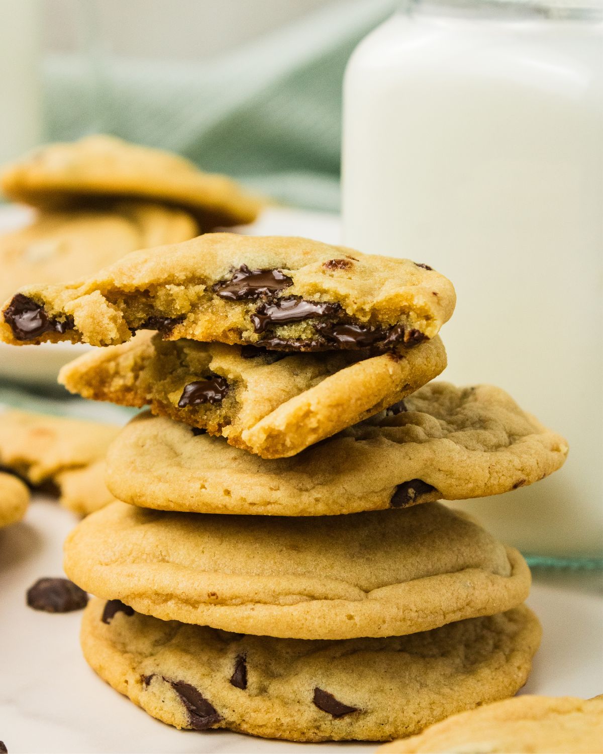 A stack of eggless chocolate chip cookies with a bite out of the top two cookies.