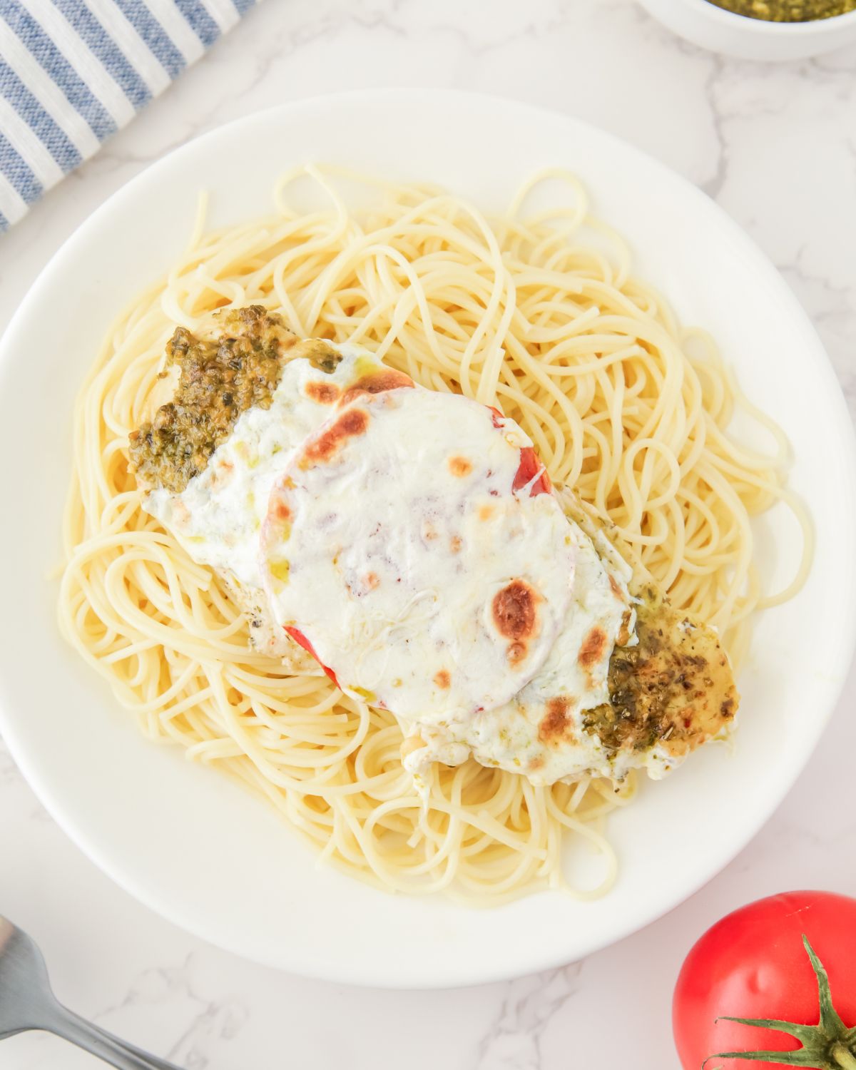 Spaghetti topped with a pesto baked chicken with fresh mozzarella. 