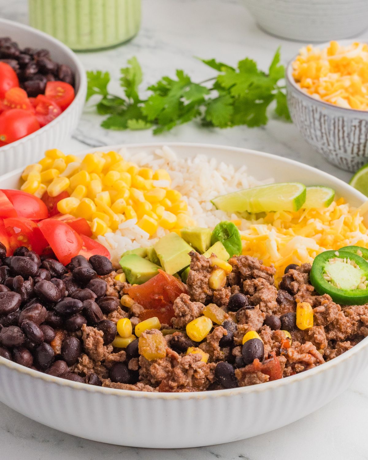 Mexican beef rice burrito bowls with corn, black beans and jalapenos.