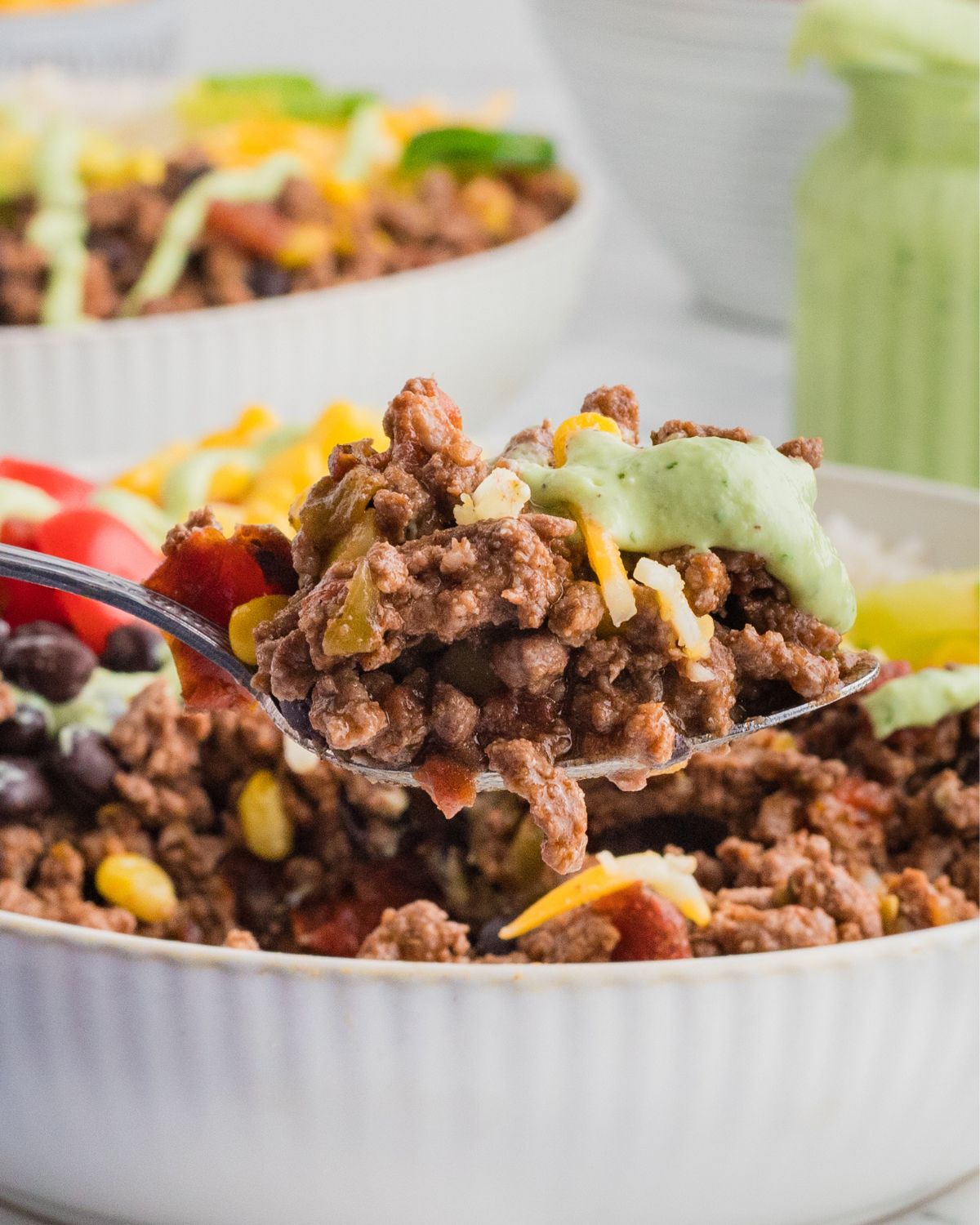 A spoonful of beef burrito bowl on a spoon.