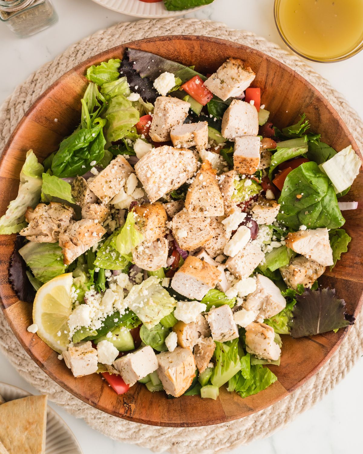 A large salad bowl with chicken marinated in greek marinade to make a chicken greek salad.