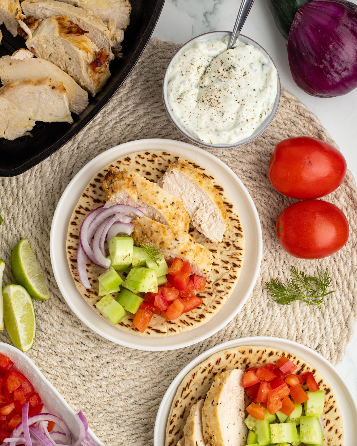 Grilled Greek chicken Gyros on pita bread with tzatziki, cucumber, red onion, and tomato.