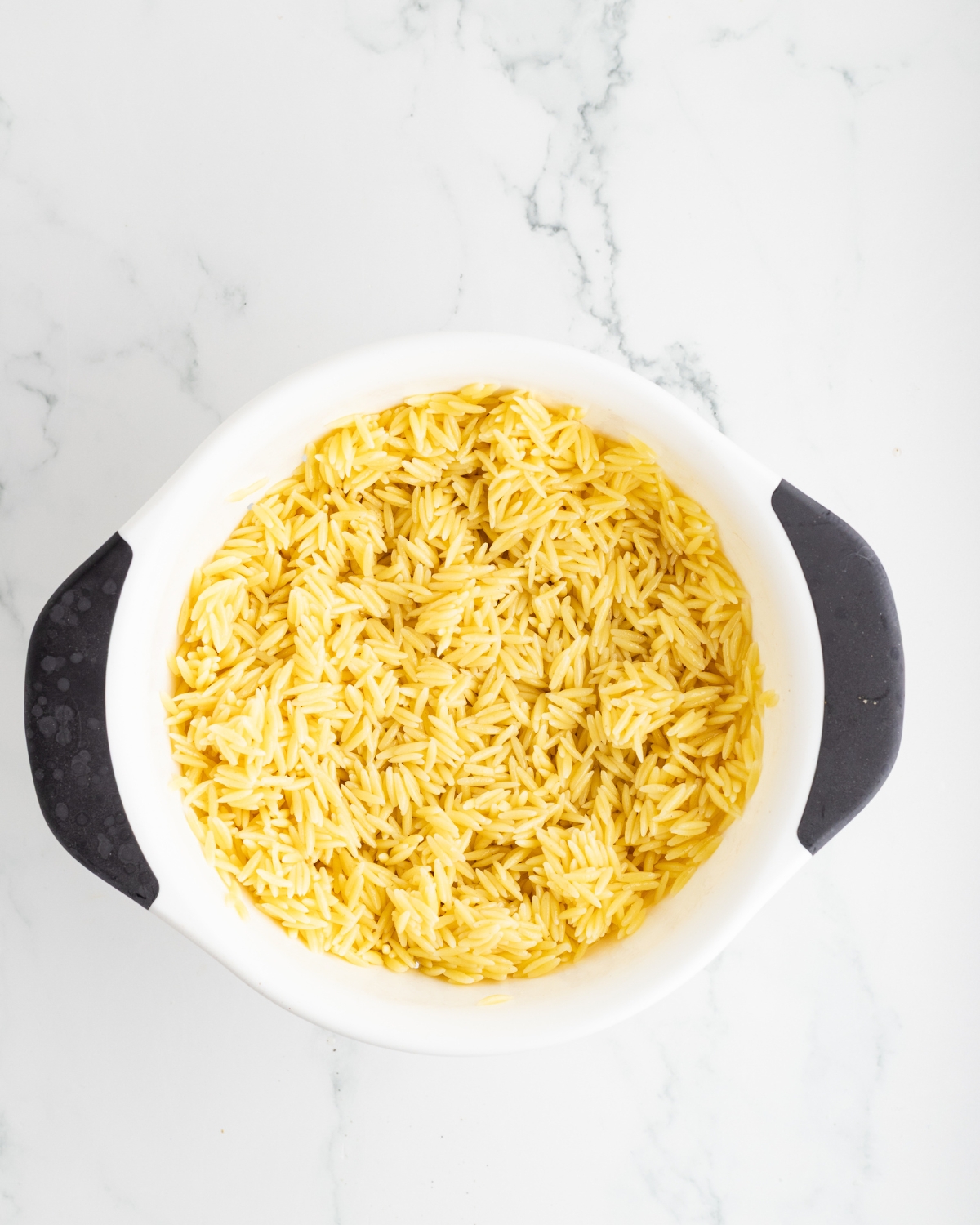 A bowl of cooked orzo for a Greek Orzo Pasta salad