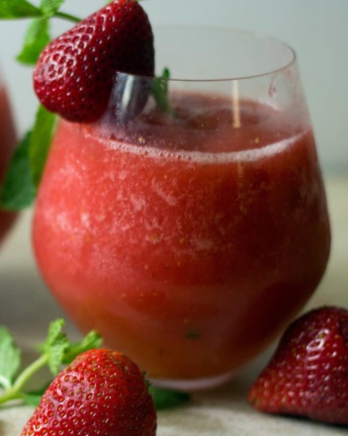 A strawberry vodka slush with mint and a strawberry garnish.